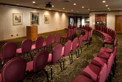 a row of chairs in a room with a podium at Carlisle Inn in Sugarcreek