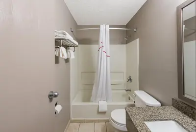 a bathroom with a toilet and a tub and a sink at Red Roof Inn Mansfield in Mansfield