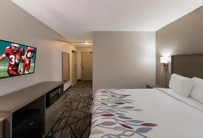 a hotel room with a bed and a flat screen tv at Red Roof Inn Mansfield in Mansfield