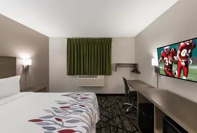 a hotel room with a bed and a flat screen tv at Red Roof Inn Mansfield in Mansfield