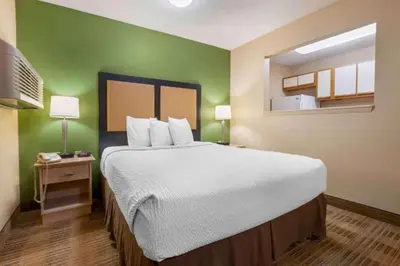 a large bed in a room with a green wall at Studio 6 Extended stay Florence, KY - Meijer Dr - Cincinnati in Florence