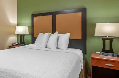a bedroom with a bed with white sheets and two lamps at Studio 6 Extended stay Florence, KY - Meijer Dr - Cincinnati in Florence