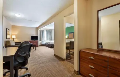 a hotel room with a desk and a bedroom at Studio 6 Extended stay Florence, KY - Meijer Dr - Cincinnati in Florence