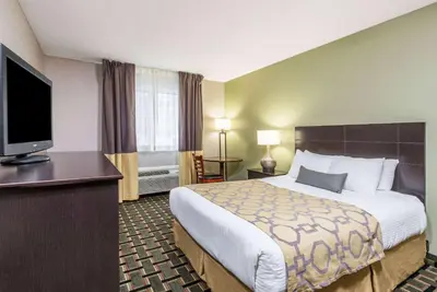 a hotel room with a bed and a flat screen tv at Baymont by Wyndham Cambridge in Cambridge