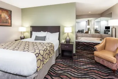 a hotel room with two beds and a bathroom at Baymont by Wyndham Cambridge in Cambridge
