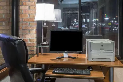 a desk with a computer monitor and a printer at Baymont by Wyndham Cambridge in Cambridge