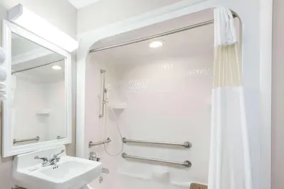 a white bathroom with a sink and a shower at Baymont by Wyndham Cambridge in Cambridge