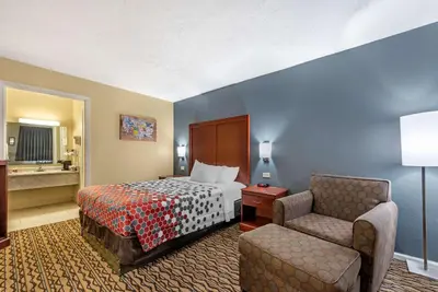 a hotel room with a bed and a chair at Econo Lodge Erlanger - Cincinnati Airport in Erlanger