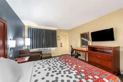 a hotel room with a bed and a flat screen tv at Econo Lodge Erlanger - Cincinnati Airport in Erlanger