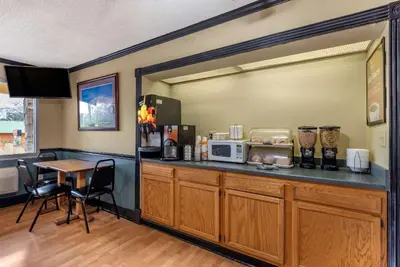 a kitchen with a counter with a microwave and a table at Econo Lodge Erlanger - Cincinnati Airport in Erlanger