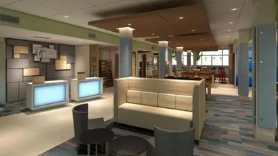 a lobby with two monitors and chairs and tables at Holiday Inn Express & Suites Ripley by IHG in Ripley