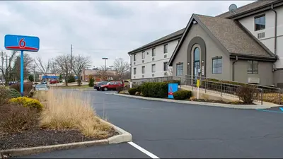 a building with a street sign in a parking lot at Studio Lodge - Cincinnati - Springdale in Springdale
