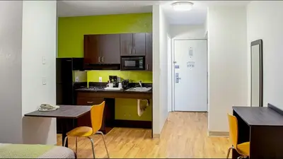 a kitchen with a table and a kitchen with green walls at Studio Lodge - Cincinnati - Springdale in Springdale