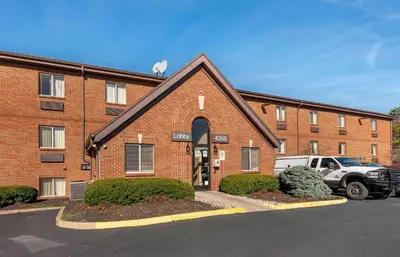a brick building with a car parked in front of it at Extended Stay America Suites - Cincinnati - Blue Ash - Reagan Hwy in Blue Ash