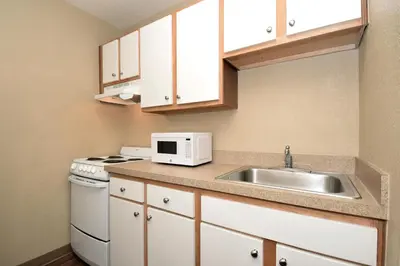a small kitchen with a sink and a microwave at Suburban Studios Columbus - Dublin in Dublin