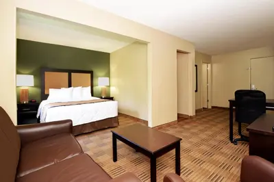 a hotel room with a bed and a couch at Suburban Studios Columbus - Dublin in Dublin