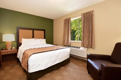 a bedroom with a bed and a chair and a window at Suburban Studios Columbus - Dublin in Dublin