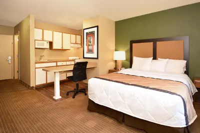 a hotel room with a bed and a desk at Suburban Studios Columbus - Dublin in Dublin