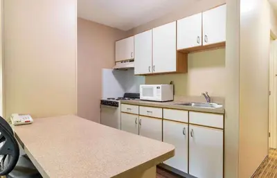 a small kitchen with white cabinets and a sink at Extended Stay America Suites - Dayton - South in Dayton