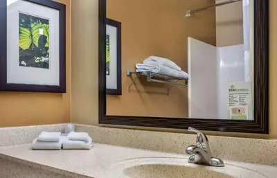 a bathroom with a sink with a mirror and towels at Extended Stay America Suites - Dayton - South in Dayton