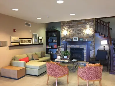 a living room with a couch and a fireplace at Country Inn & Suites by Radisson, Lima in Lima