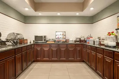 a large kitchen with wooden cabinets and appliances at Country Inn & Suites by Radisson, Lima in Lima
