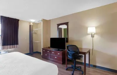 a hotel room with a bed and a desk with a television at Extended Stay America Suites - Cleveland - Westlake in Westlake