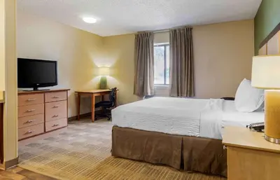 a hotel room with a bed and a flat screen tv at Extended Stay America Suites - Toledo - Maumee in Maumee