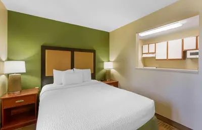 a bedroom with a white bed and a green wall at Extended Stay America Suites - Toledo - Maumee in Maumee