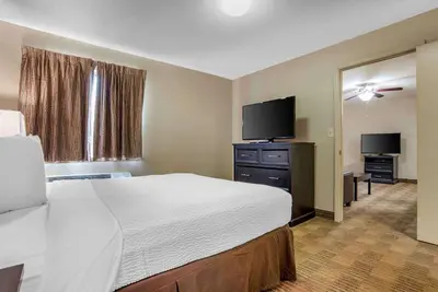 a hotel room with a bed and a flat screen tv at Extended Stay America Suites - Toledo - Maumee in Maumee