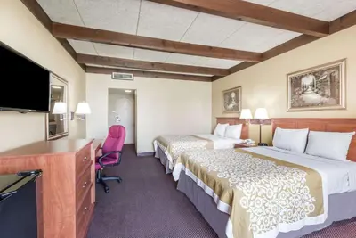 a hotel room with two beds and a flat screen tv at Days Inn by Wyndham Niles in Niles