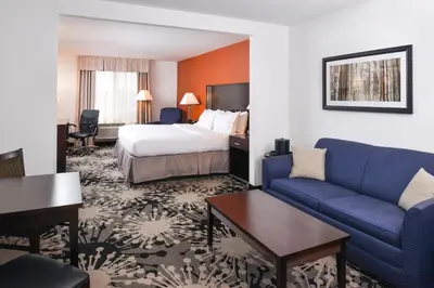 a hotel room with a bed and a couch at Holiday Inn Express & Suites Greenfield by IHG in Greenfield