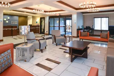 a lobby of a hotel with chairs and tables at Holiday Inn Express & Suites Greenfield by IHG in Greenfield