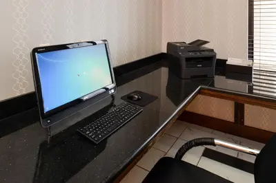 a desk with a computer monitor and a keyboard and mouse at Holiday Inn Express & Suites Greenfield by IHG in Greenfield