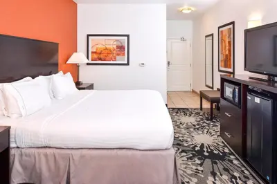 a hotel room with a large bed and a flat screen tv at Holiday Inn Express & Suites Greenfield by IHG in Greenfield