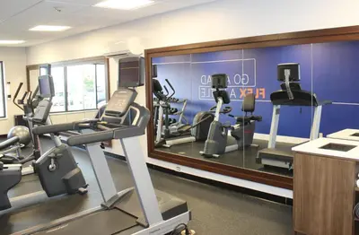 a gym with several tread machines and a mirror at Holiday Inn Express & Suites Greenfield by IHG in Greenfield