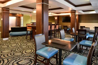 a restaurant with tables and chairs and a television at Holiday Inn Express & Suites Greenfield by IHG in Greenfield