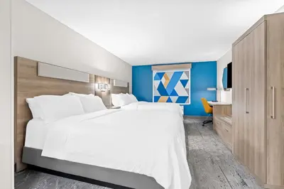 a bedroom with a large white bed and a desk at Holiday Inn Express Washington Court House by IHG in Washington Court House