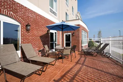 a group of chairs and an umbrella on a patio at Holiday Inn Express Washington Court House by IHG in Washington Court House