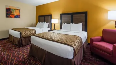 a hotel room with two beds and a chair at Best Western B R Guest in Zanesville
