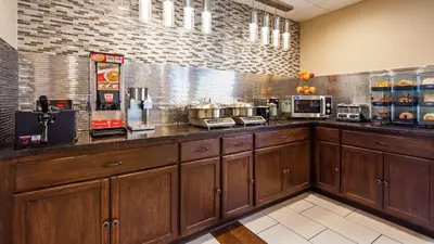 a kitchen with wooden cabinets and a counter top at Best Western B R Guest in Zanesville