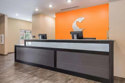 an office lobby with an orange wall and a reception desk at Comfort Suites Marysville Columbus - Northwest in Marysville