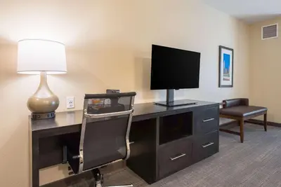 a room with a desk with a television and a chair at Comfort Suites Marysville Columbus - Northwest in Marysville