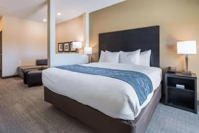 a hotel room with a large bed and a chair at Comfort Suites Marysville Columbus - Northwest in Marysville