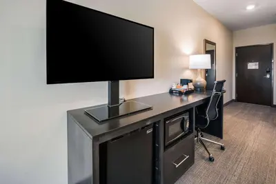 a room with a desk with a flat screen tv on a wall at Comfort Suites Marysville Columbus - Northwest in Marysville