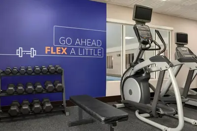 a gym with a treadmill and a sign that says go ahead flex aittle at Holiday Inn Express & Suites North Fremont by IHG in Fremont