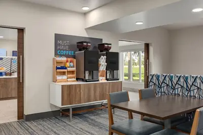 a dining room with a table and a coffee shop at Holiday Inn Express & Suites North Fremont by IHG in Fremont