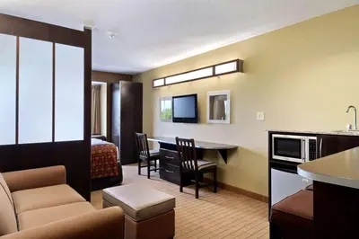 a hotel room with a bed and a living room at Microtel Inn & Suites by Wyndham Marietta in Marietta