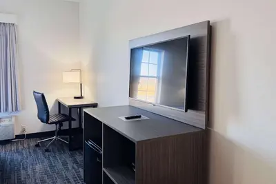 a hotel room with a large flat screen tv on a wall at Ramada by Wyndham Sparta/At Speedway in Sparta