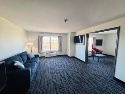 a living room with a couch and a room with a mirror at Ramada by Wyndham Sparta/At Speedway in Sparta